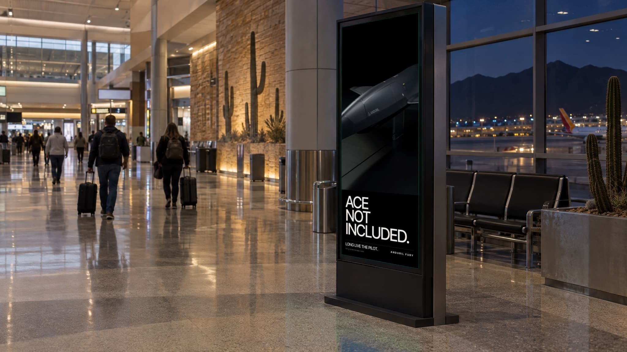 A tall digital screen in an airport concourse at dusk showing the motion poster: Fury alone and ACE NOT INCLUDED. Travelers walk past with their bags