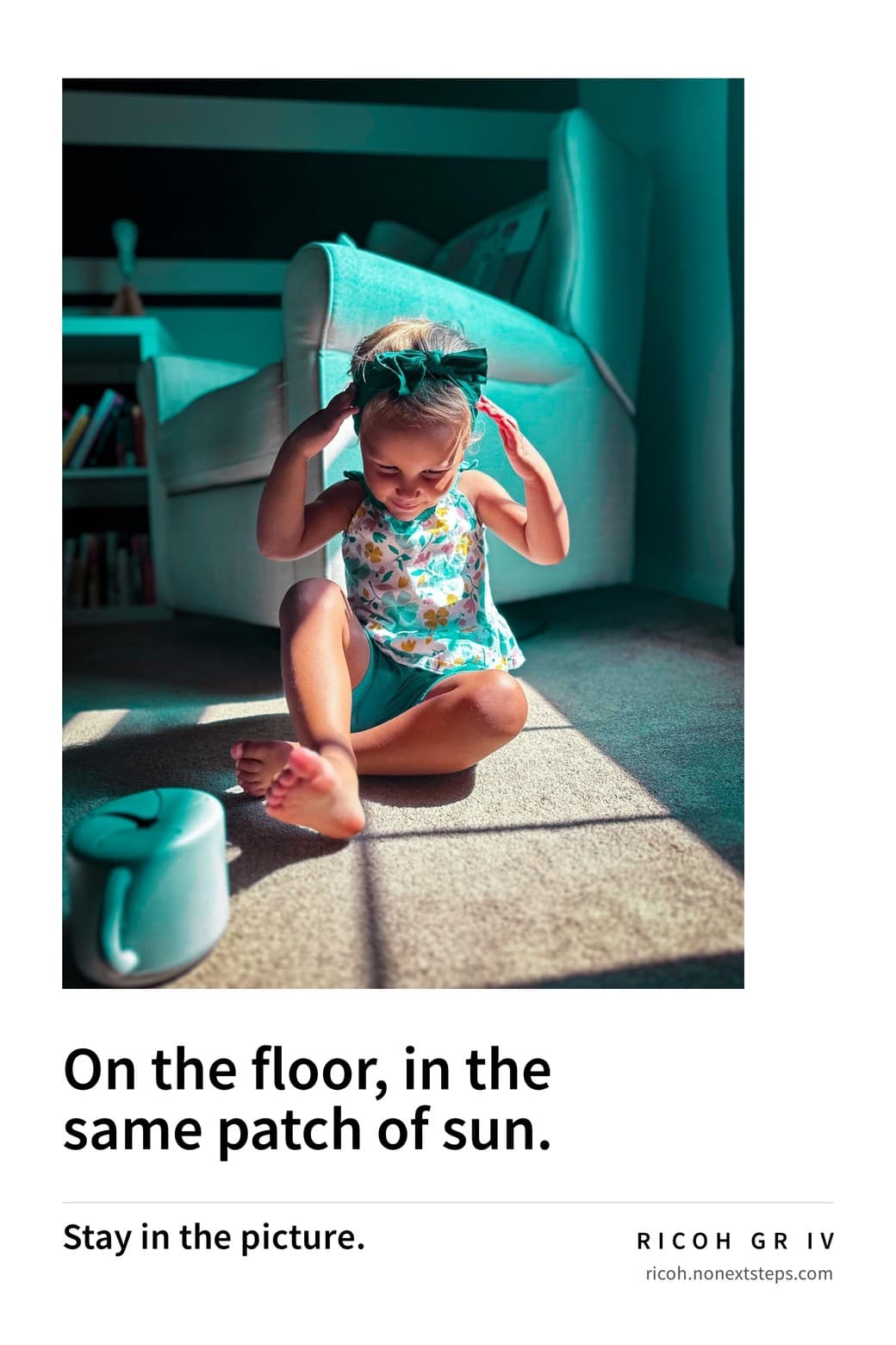 Poster: a toddler in a patch of morning sun fixing her hair bow. On the floor, in the same patch of sun. Stay in the picture. RICOH GR IV